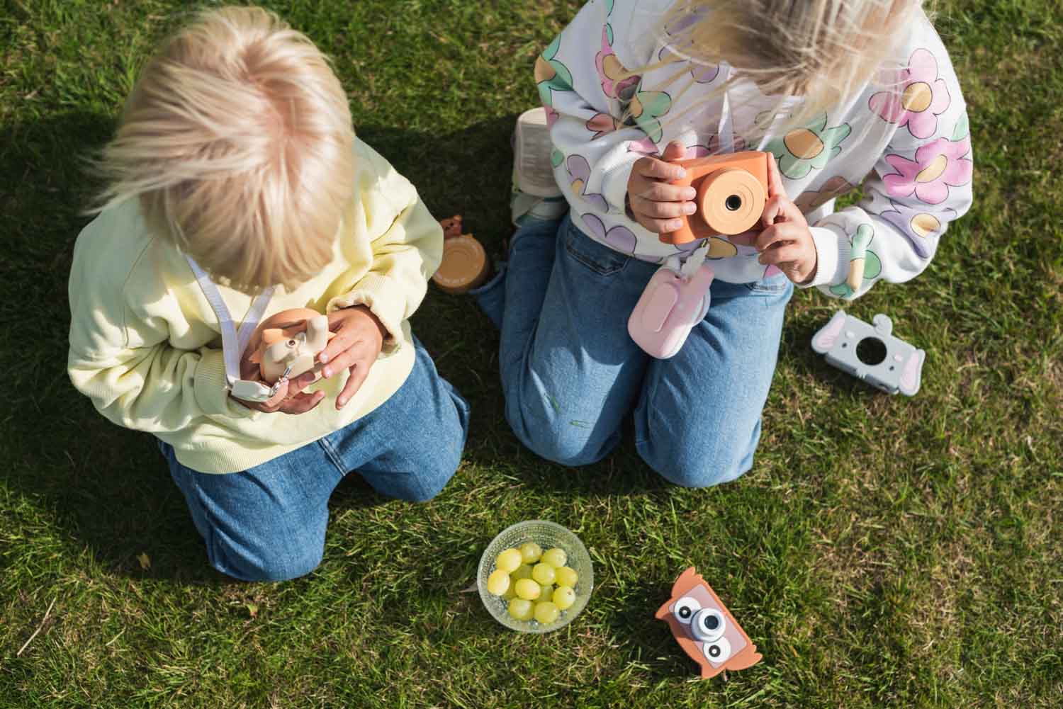 owl digital kids camera, children sitting outside while playing with the cameras and walki talki