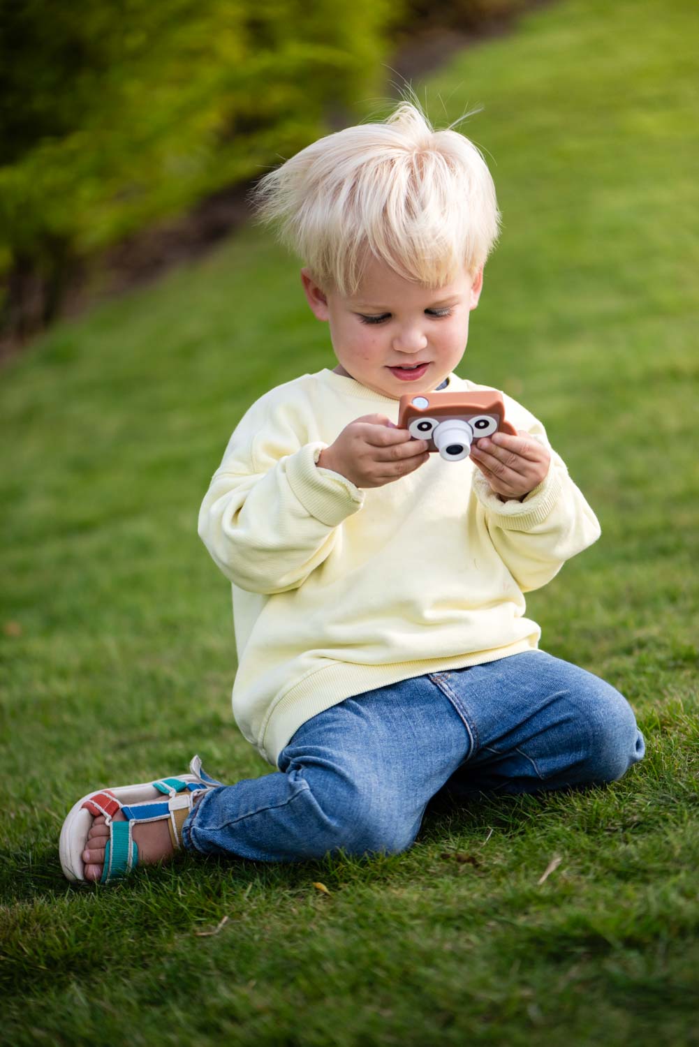 owl digital kids camera, child is sitting in the garden, playing with the camera