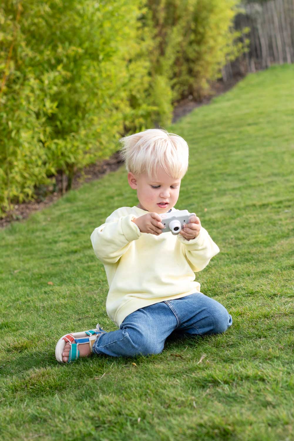 elephant digital kids camera, child is sitting outside looking at the camera in its hands