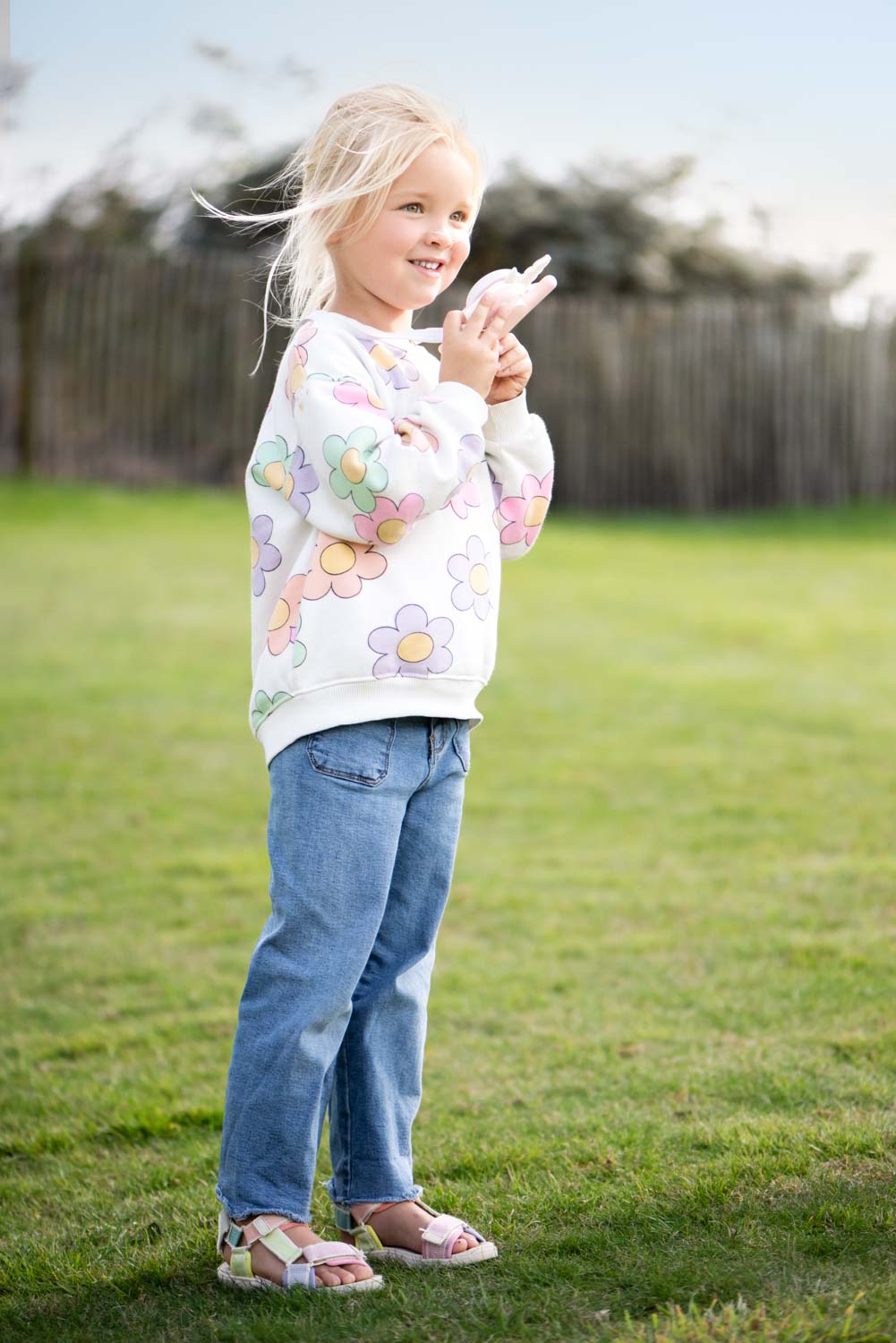 zoo walkie talkie unicorn, child is holding the walkie talkie around its neck, standing outside