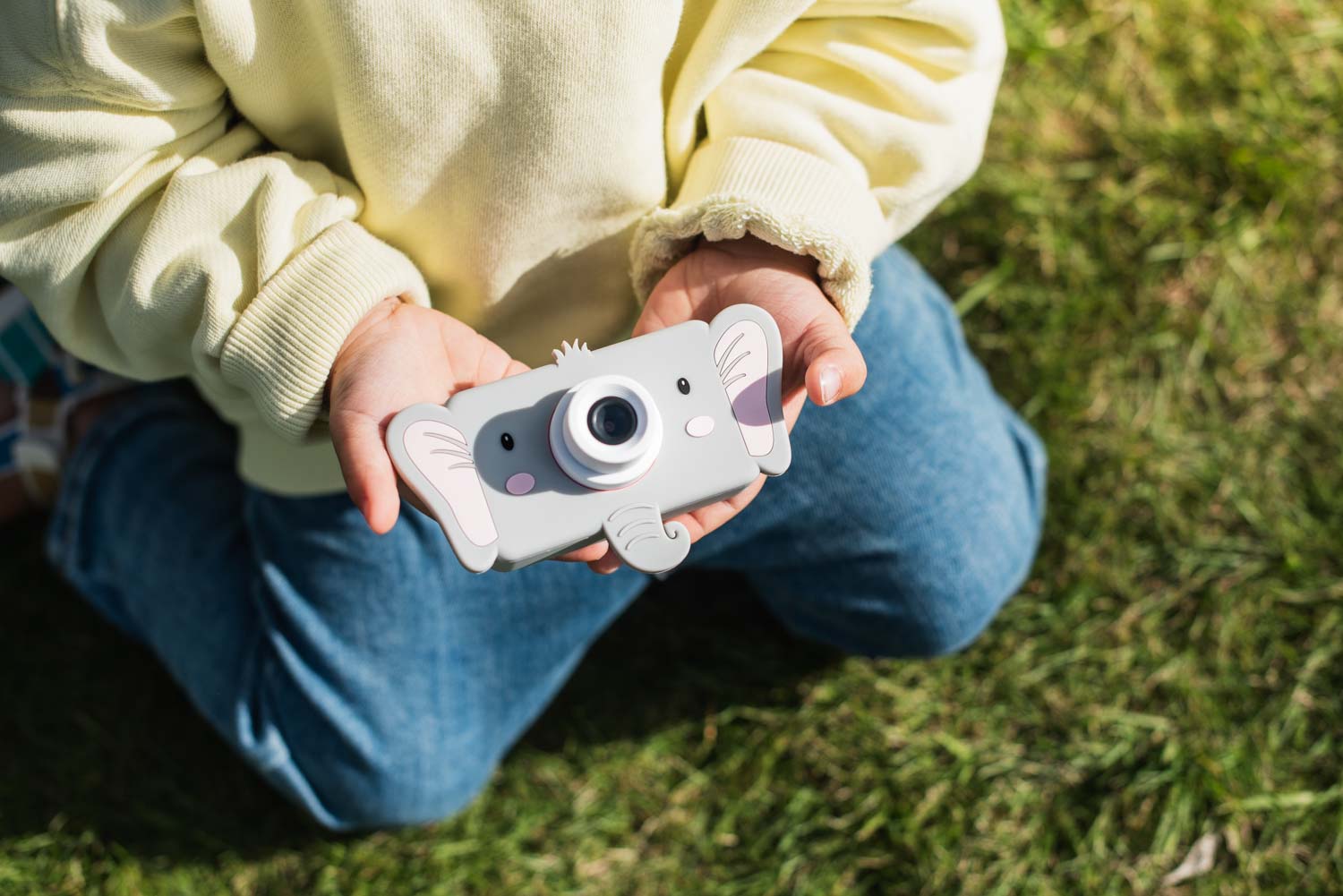 elephant digital kids camera, chld is sitting outside holding the camera into its hands