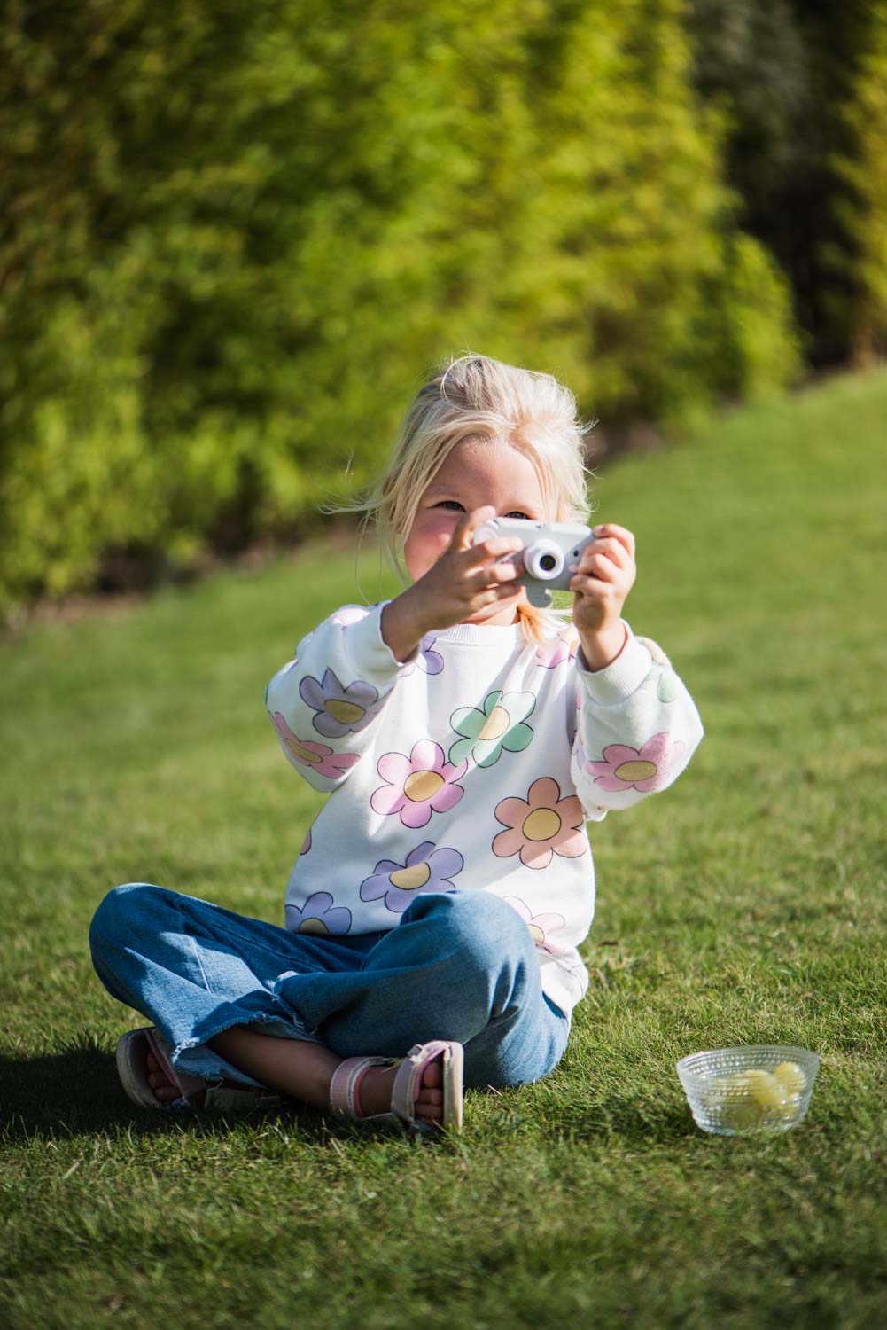 elephant digital kids camera, child is sitting outside and laughing while taking pictures