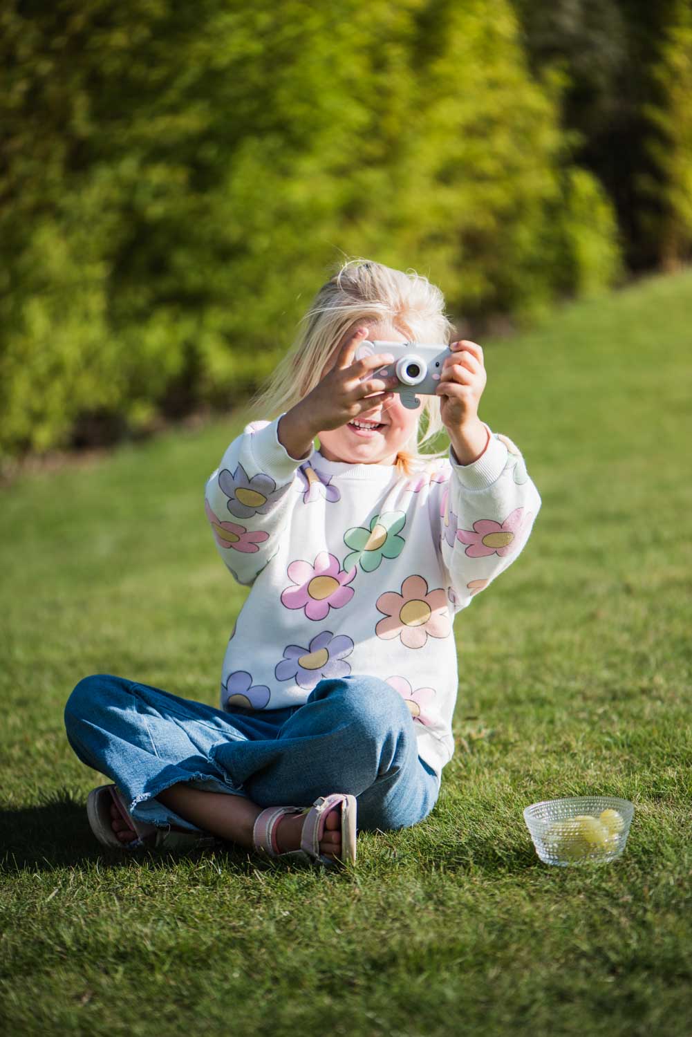 elephant digital kids camera, child is sitting outside while taking pictures