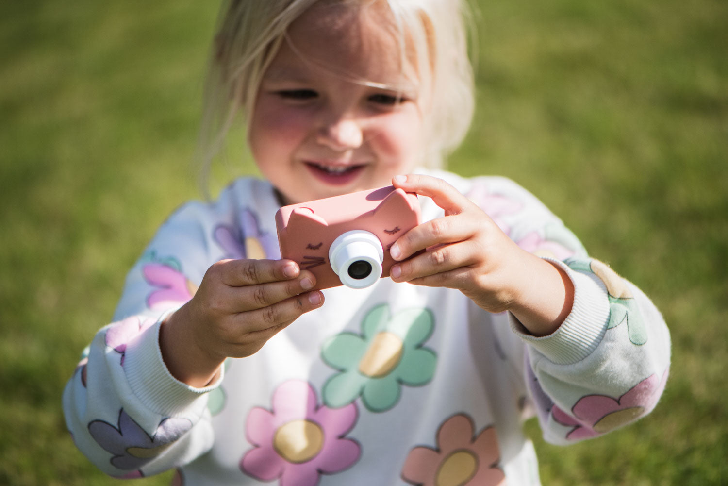 zoo friends cat digital kids camera, child is standing in the garden while playing with the camera