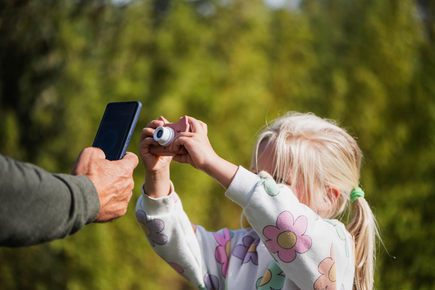 zoo friends cat digital kids camera, child is taking a picture of a mobile phone held by an adult
