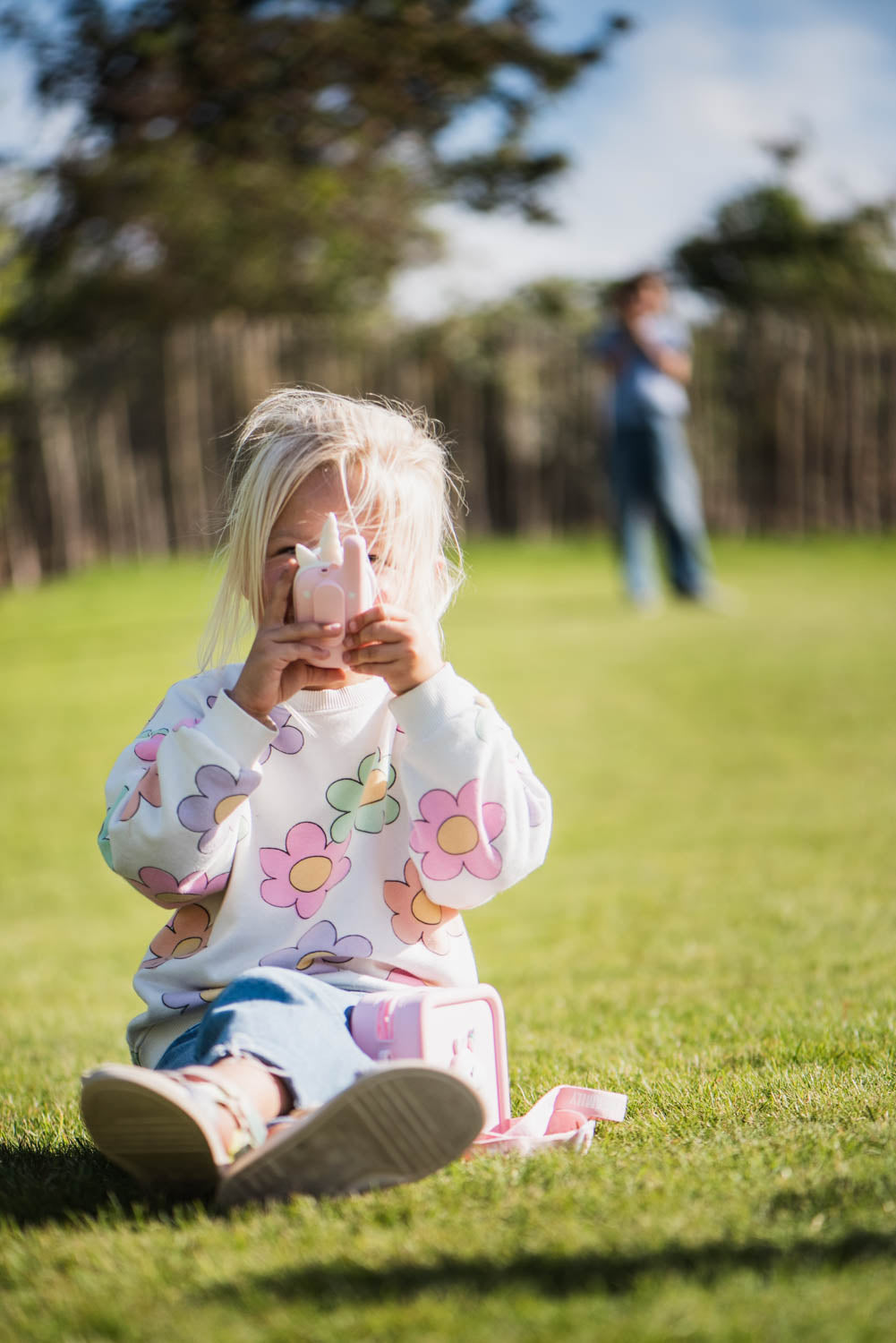 zoo walkie talkie unicorn, child is speaking into the walkie talkie while sitting in the garden