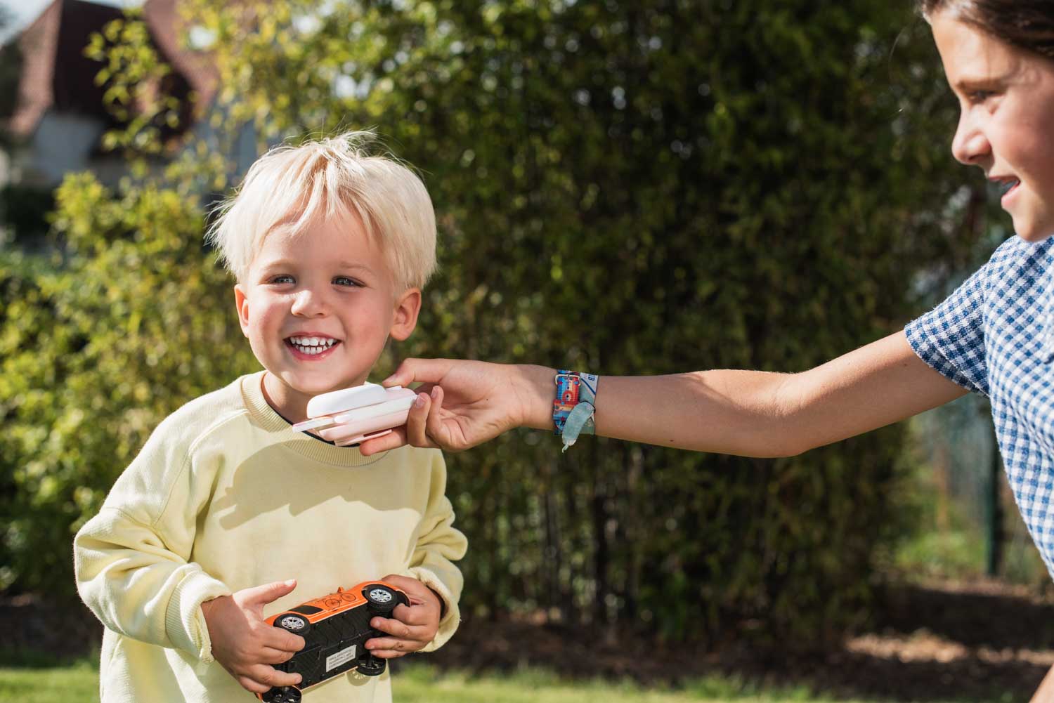 zoo walkie talkie unicorn, child is holding the walkie talkie while the other child is speaking into it, holding a car toy