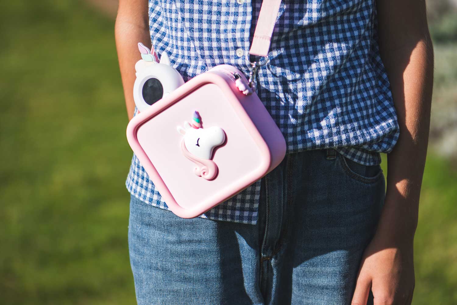silicon bag unicorn, child is carrying the bag over its shoulder, walkie talkie unicorn in the bag