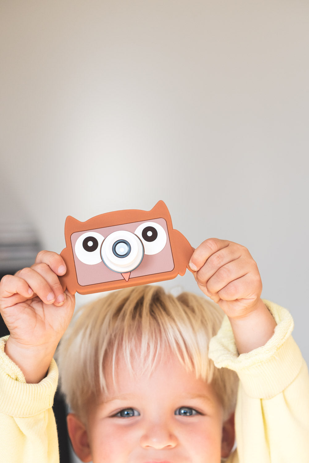 owl digital kids camera, child is proudly holding the camera up in the air