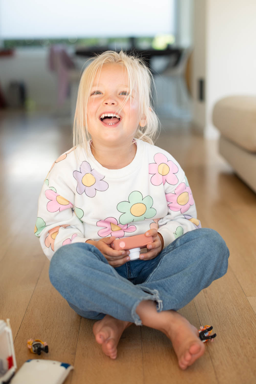 zoo friends cat digital kids camera, child is playing with playmobil while sitting on the ground and holding the camera