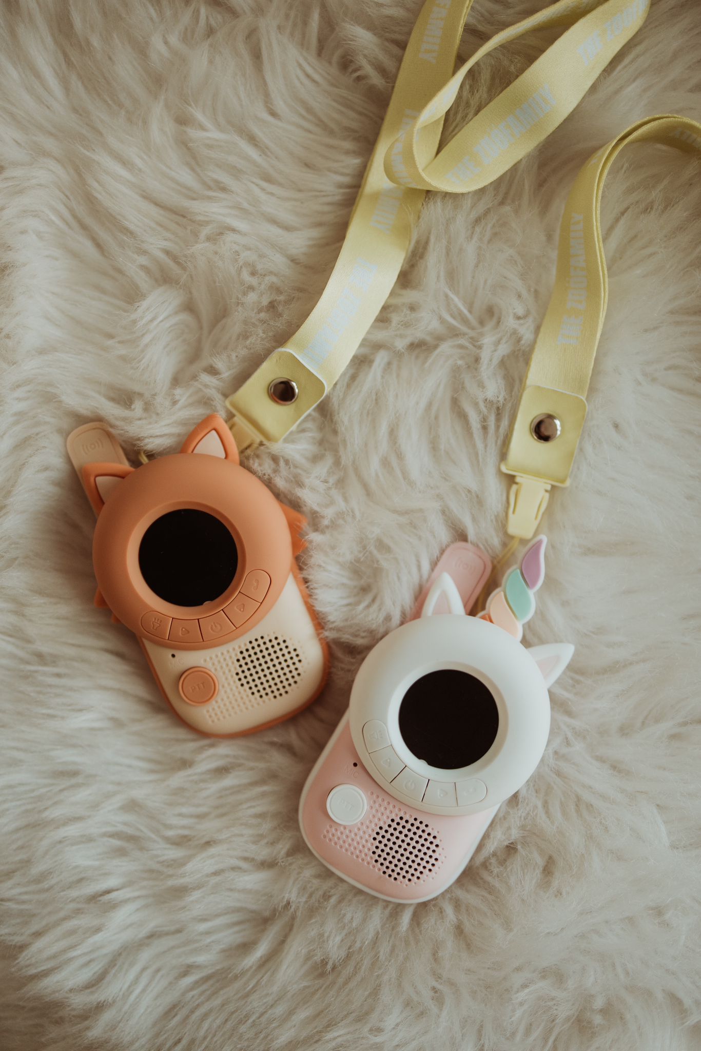 zoo walkie talkie set fox and unicorn, lying on a pillow