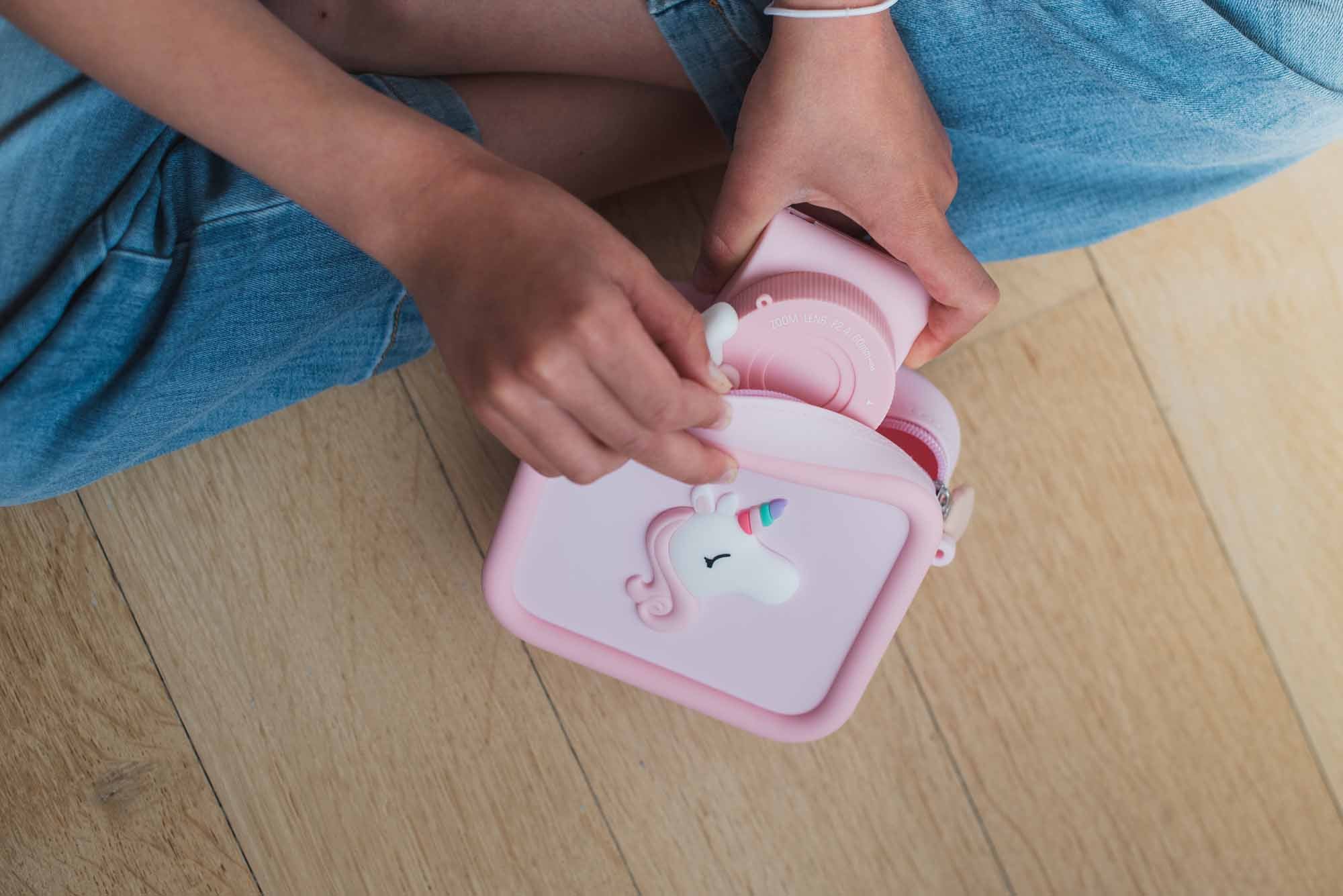 Unicorn Bag for pink Periwinkle the Unicorn digital kids camera, child is putting the camera into the bag