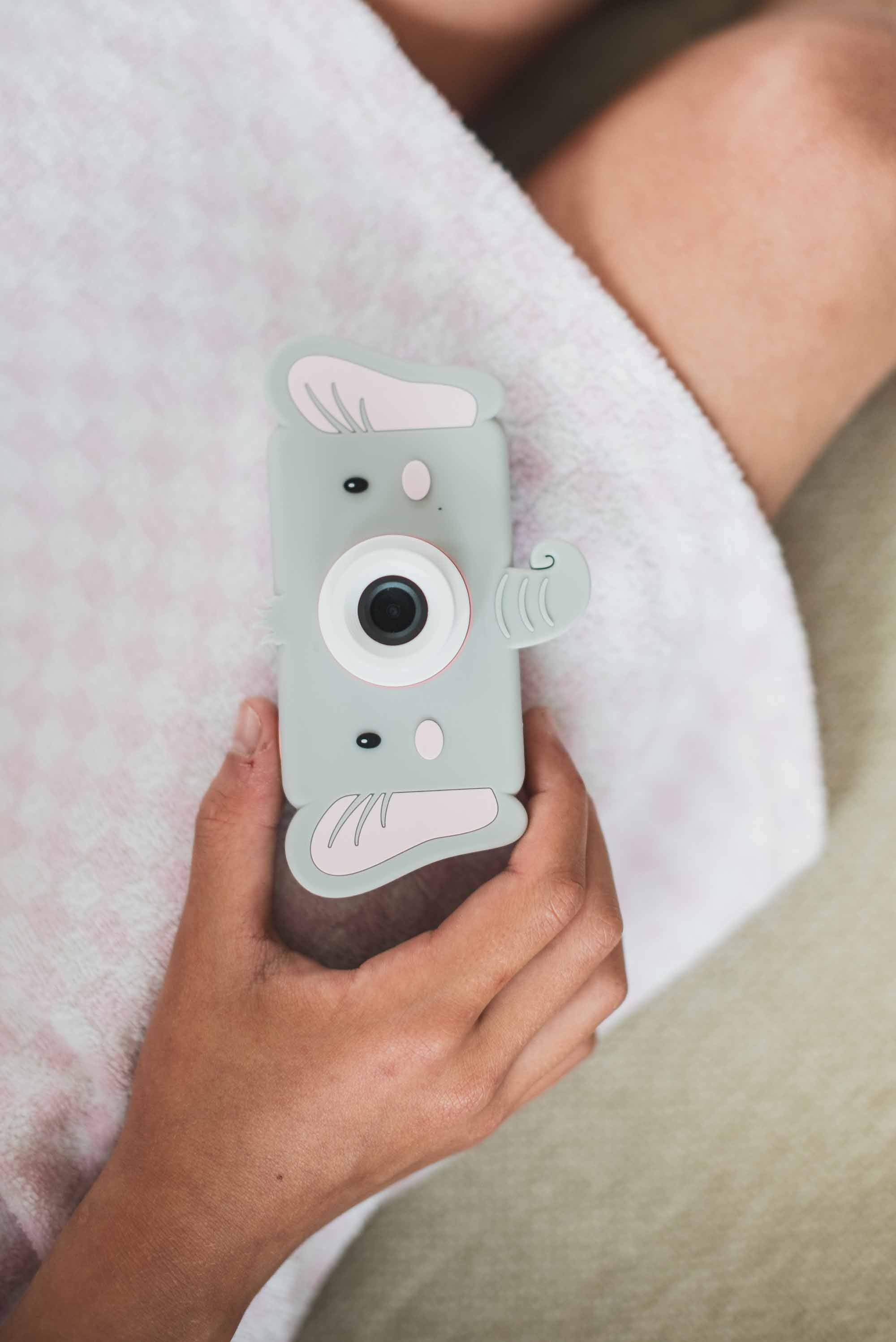 pink digital kids camera with elephant sleeve, child holding the camera in het hand