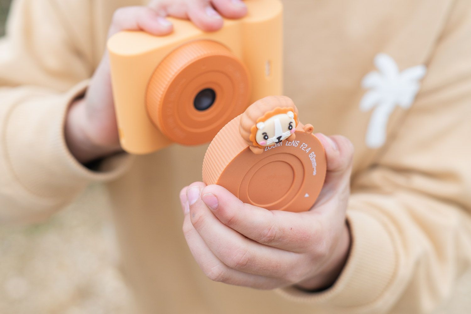 urban zoo lion digital kids camera, child is taking off the lenscover of the camera