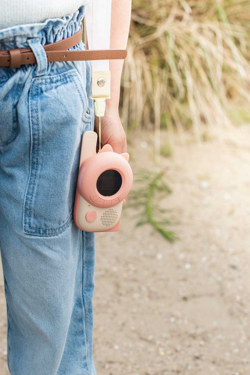 zoo walkie talkie dino pink, hanging on shoulder of child, at the beach