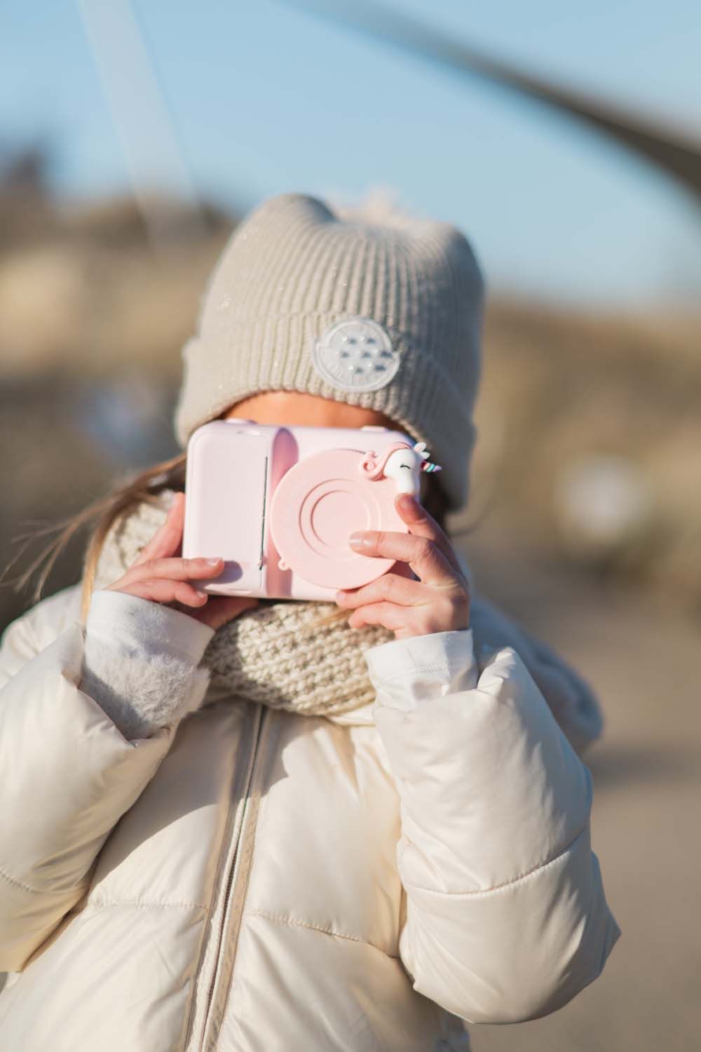 zoo print unicorn digital kids camera, child is holding the camera with lenscover in front of its face