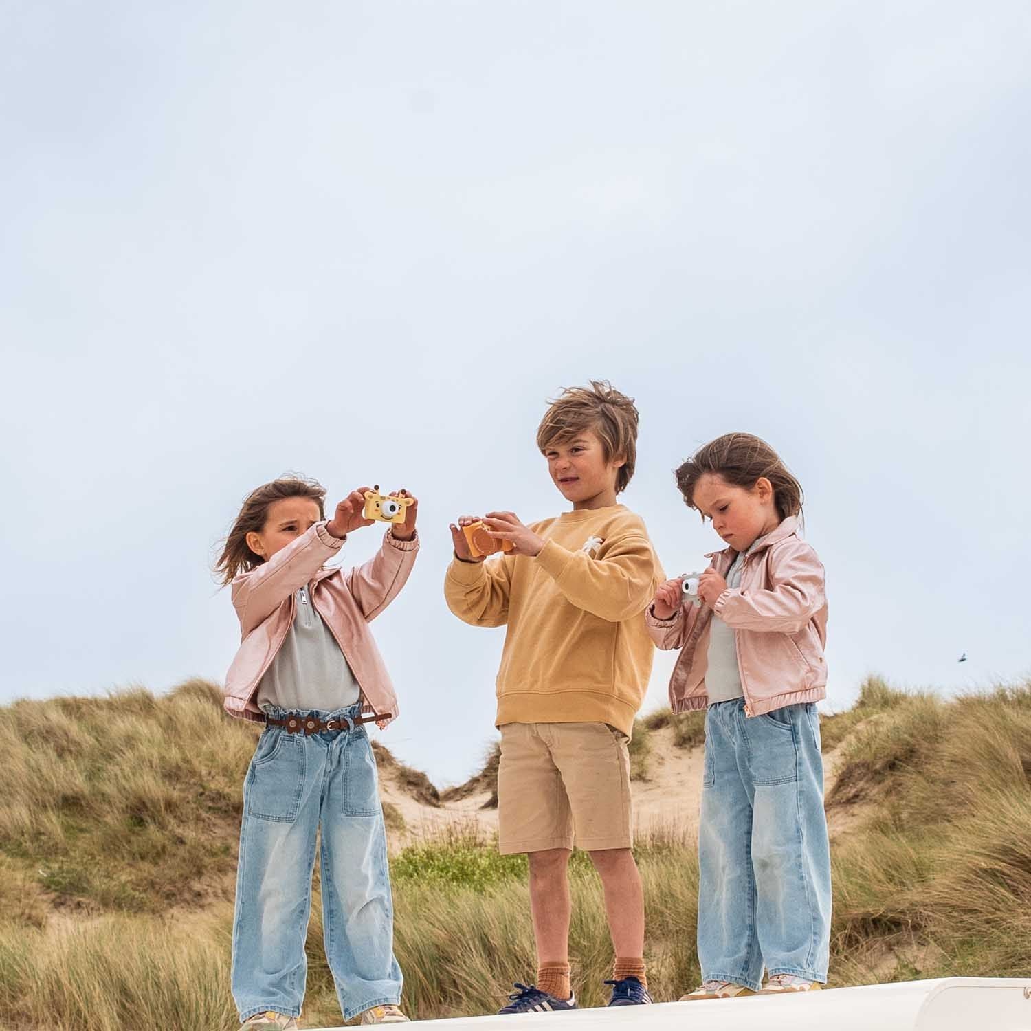 zoo friends giraffe and elephant digital kids camera and urban fox camera, children are holding the cameras while standing at the beach