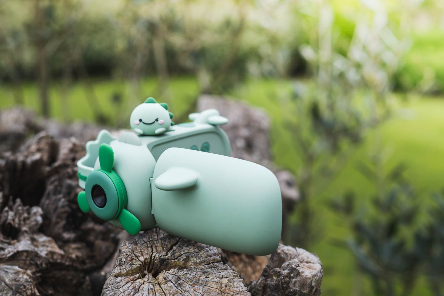 zoo video dino green digital kids camera, camera is lying on a tree trunk