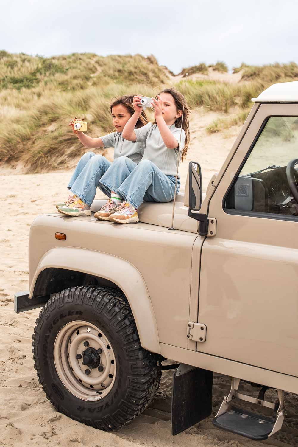zoo friends elephant and giraffe digital kids cameras, children are holding the cameras while sitting on the front of a jeep