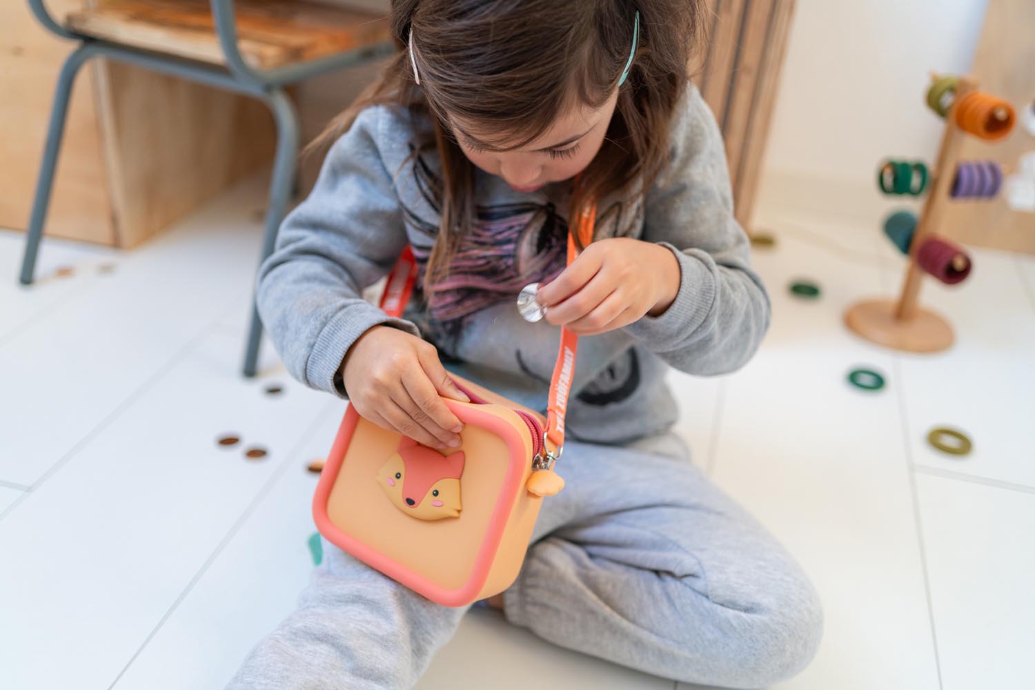 silicon bag fox, child is carrying the bag around its neck while sitting in kidsroom