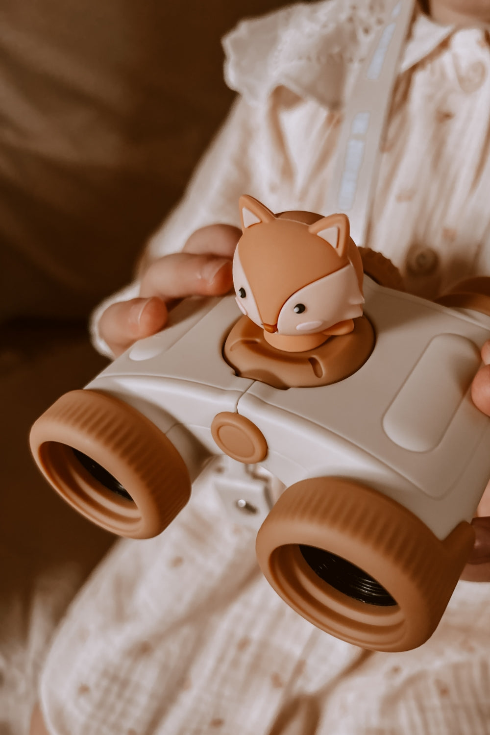 A girl is playing with her binoculars.