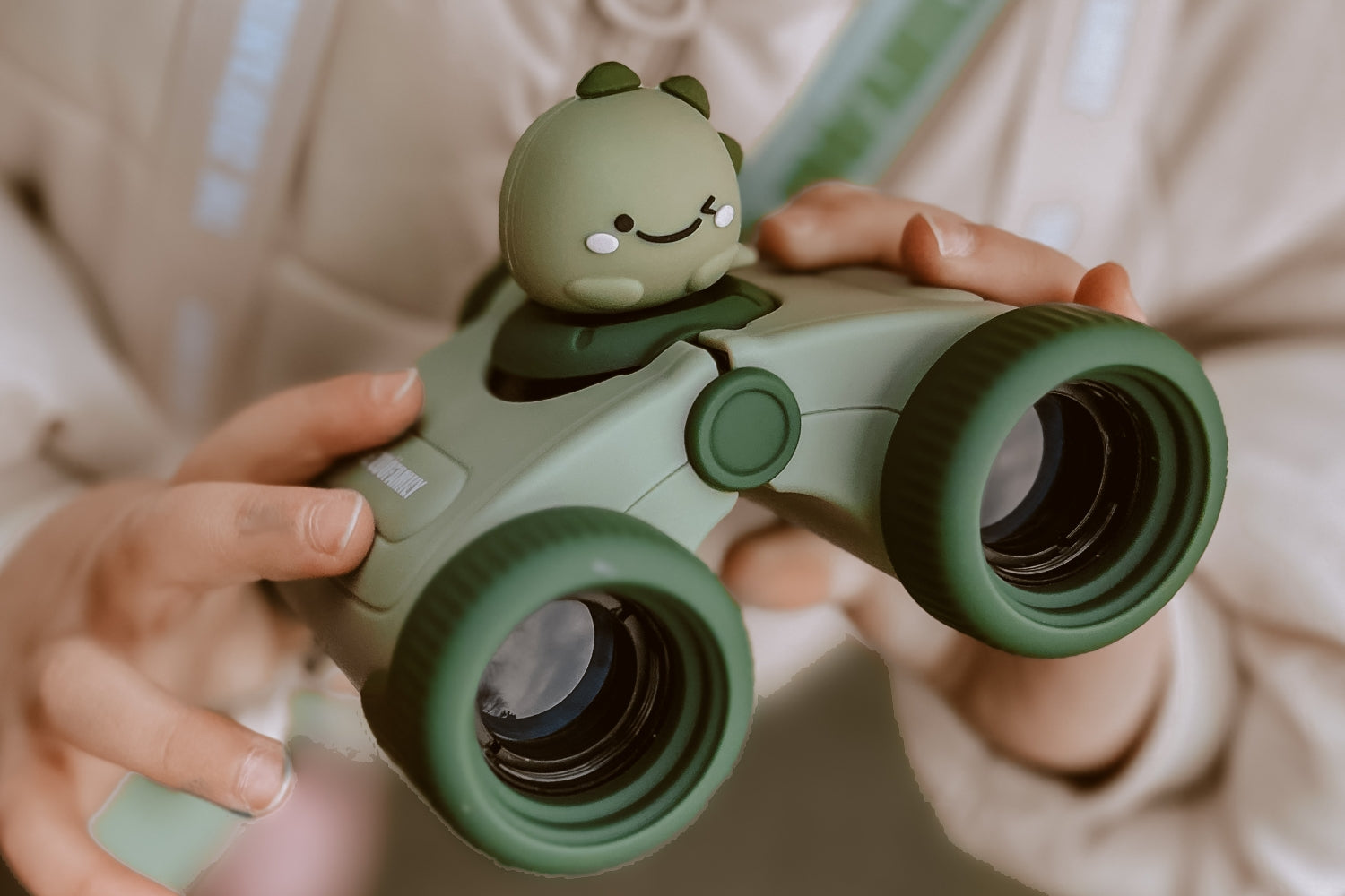 A close-up view of a girl's hands holding binoculars.
