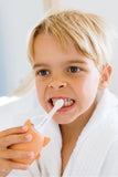odalA young blonde boy brushes his teeth with a fox toothbrush.