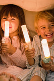 odalTwo children holding glowing Zoo Light lamps under a blanket.