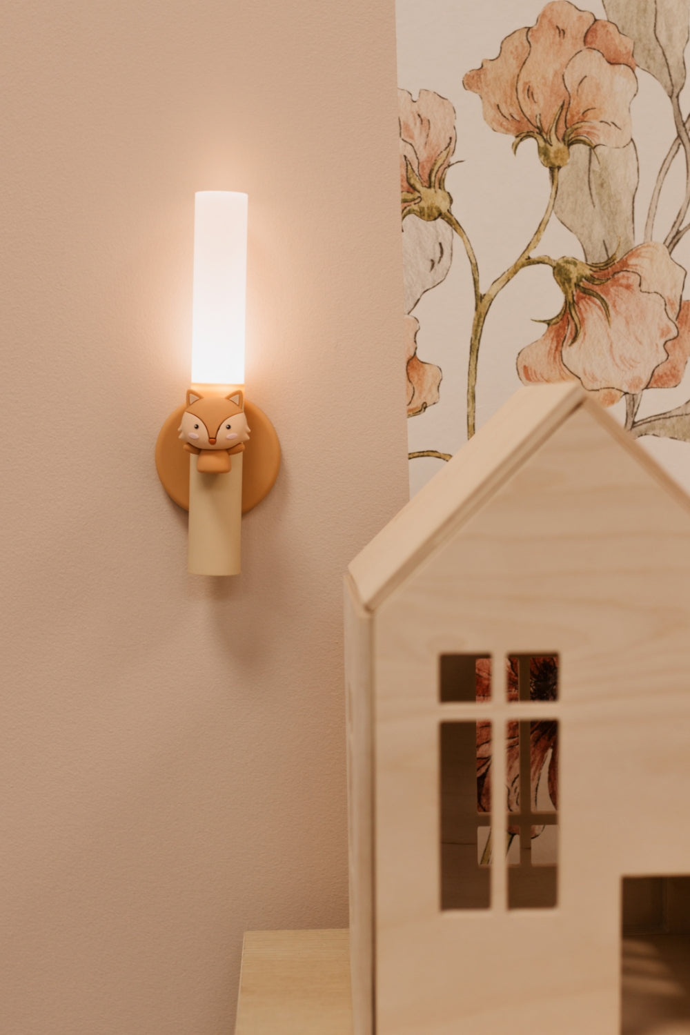 Wall sconce with a Zoo Light Fox lamp on a wall next to a floral wallpaper and a wooden dollhouse.