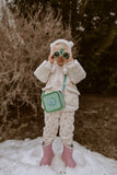 odaldino green silicon bag, child is carrying the bag around its neck, while playing with a pair of binoculars, standing in the snow