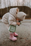 odaldino green silicon bag, child is playing outside with a pair of binoculars, ooking at wood and stones