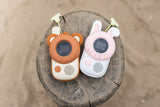 odalwalkie talkie bear and rabbit set, lying on a tree trunk