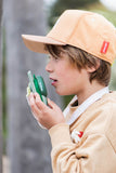 odalzoo walkie talkie dino green, child is looking in front while speaking into the walkie talkie