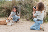 odalurban zoo unicorn digital kids camera, child is taking a picture of other child that is cuddeling the dog