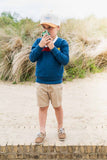 odalzoo walkie talkie dino green, child is standing at the beach, talking into the walkie talkie
