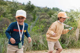 odalzoo walkie talkie set of dino green, children are running at the beach while having the walkie talkies around its necks
