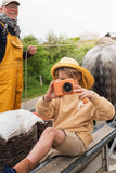 odalzoo print bear digital kids camera, child is sitting on a horse and carriage while taking a picture, wearing a fisherman's hat