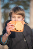 odalzoo print bear digital kids camera, child is showing the camera with lenscover