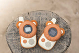 odalwalkie talkie bear set, lying on a tree trunk