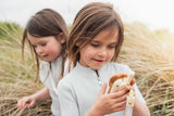 odalwalkie talkie bear, child is holding the walkie talkie while another child is walking behind