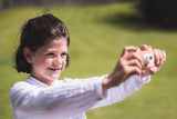 odalfox kids camera, child holding camera with both hands, laughing while making a picture