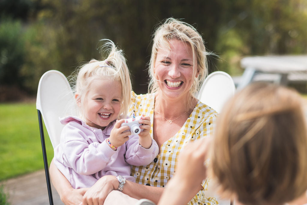 unicorn kids camera, child sitting in chair with mom, holding the camera, laughing