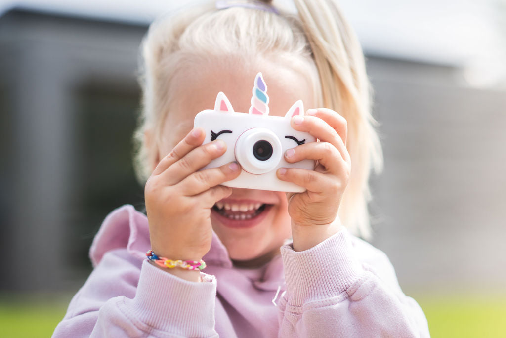 unicorn kids camera, child having the camera in both hands, making a picture