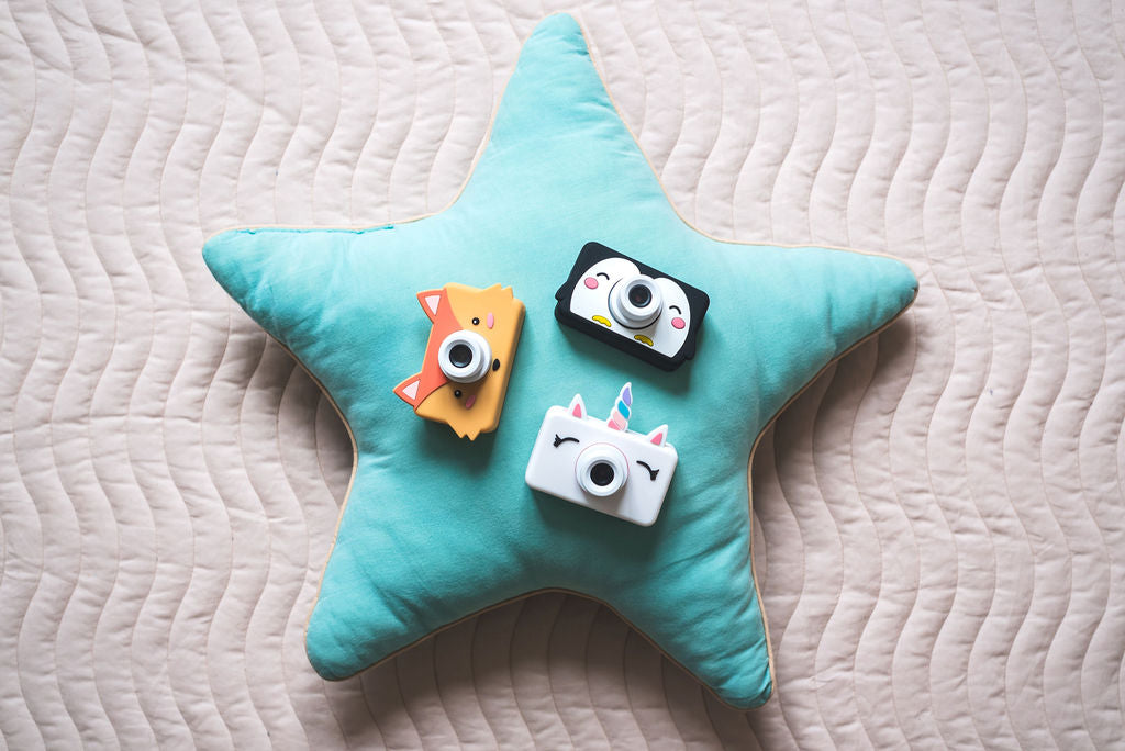 fox, penguin and unicorn kids cameras, lying on blue pillow